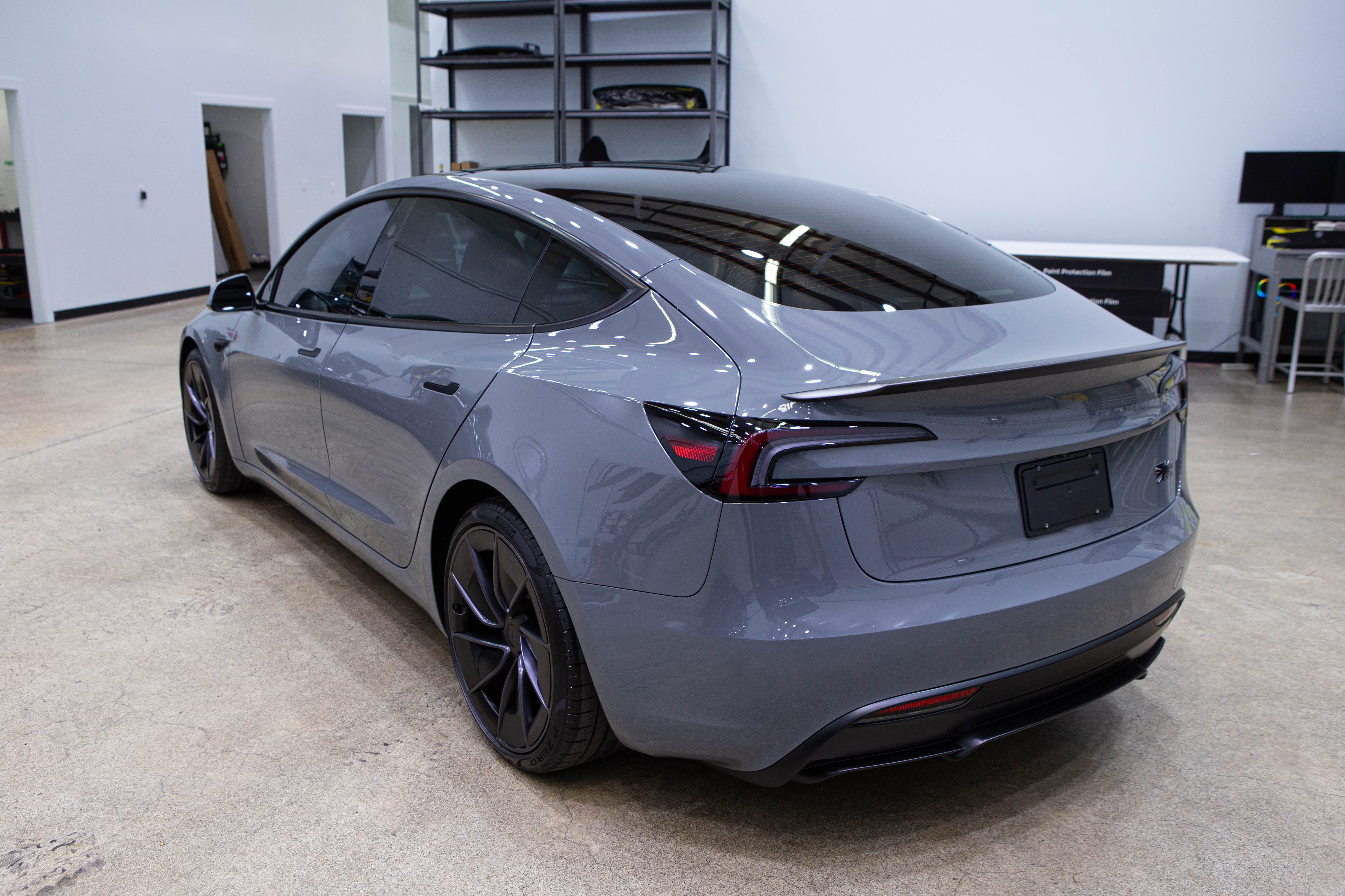 Protected grey sedan, rear three quarter